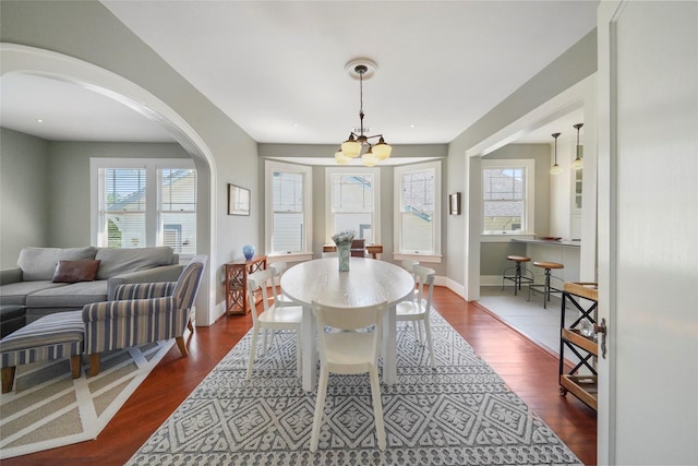 dining room featuring an inviting chandelier and dark wood-type flooring