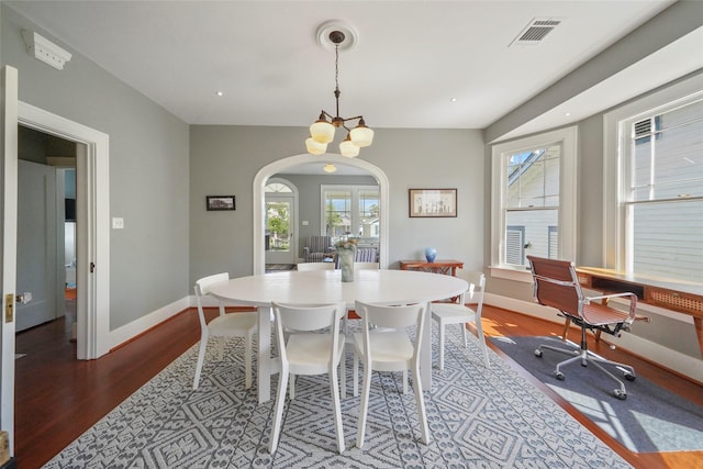 dining area featuring a notable chandelier and dark hardwood / wood-style flooring