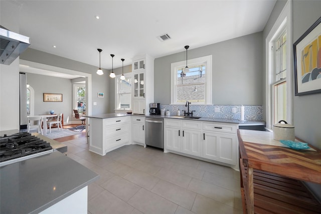 kitchen with pendant lighting, white cabinets, dishwasher, sink, and kitchen peninsula