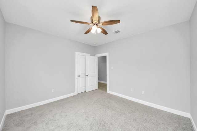 carpeted empty room featuring ceiling fan