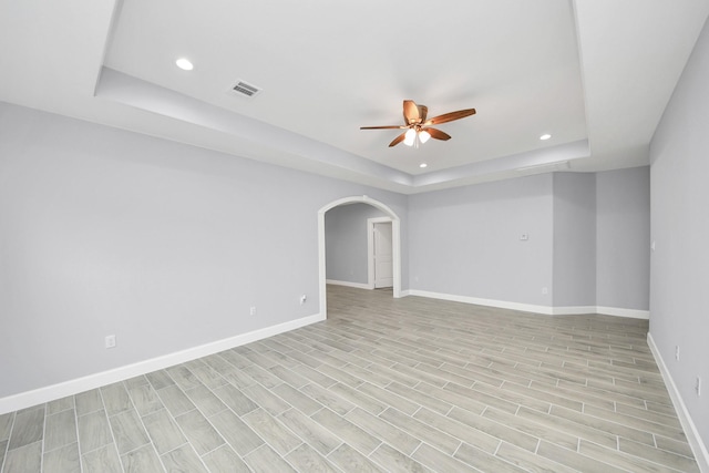 spare room featuring ceiling fan and a tray ceiling