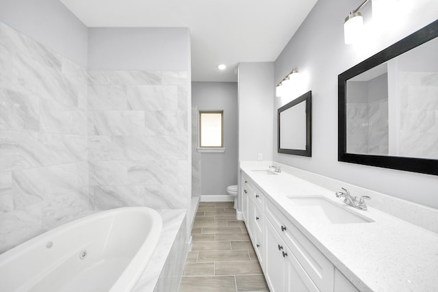 bathroom with toilet, tiled bath, and vanity