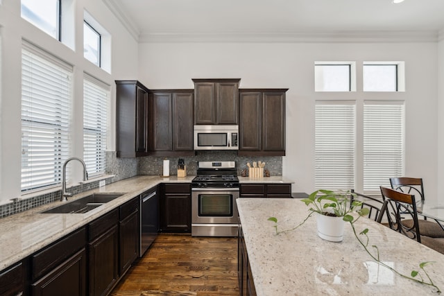 kitchen with sink, light stone countertops, and stainless steel appliances