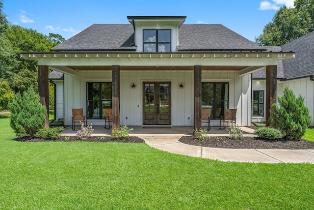 rear view of property with covered porch and a yard