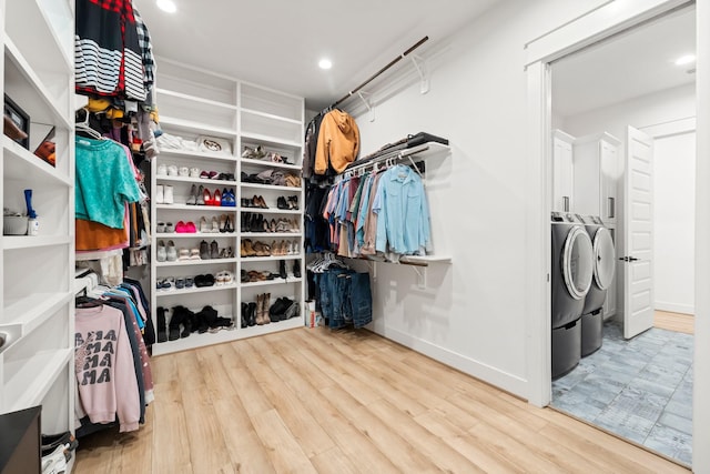 walk in closet with light hardwood / wood-style flooring and independent washer and dryer