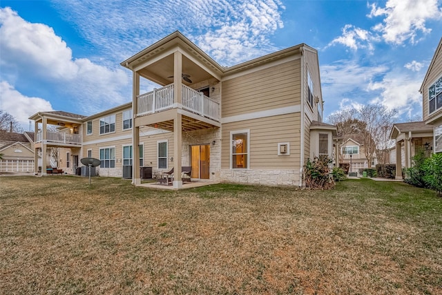 back of house with a balcony, a patio area, a lawn, and ceiling fan