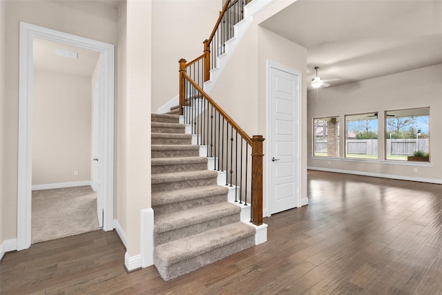 stairs featuring hardwood / wood-style flooring and ceiling fan