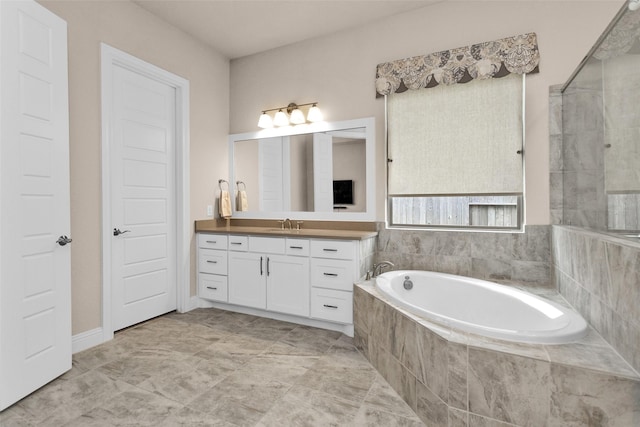 bathroom with vanity and a relaxing tiled tub