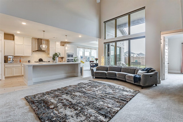 living room with a high ceiling and light colored carpet