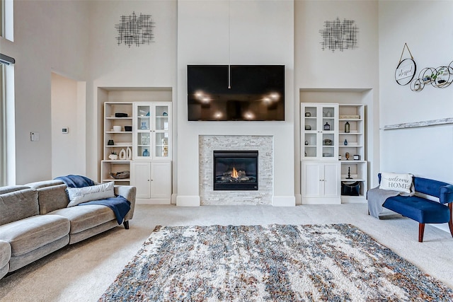 living room with a towering ceiling and carpet