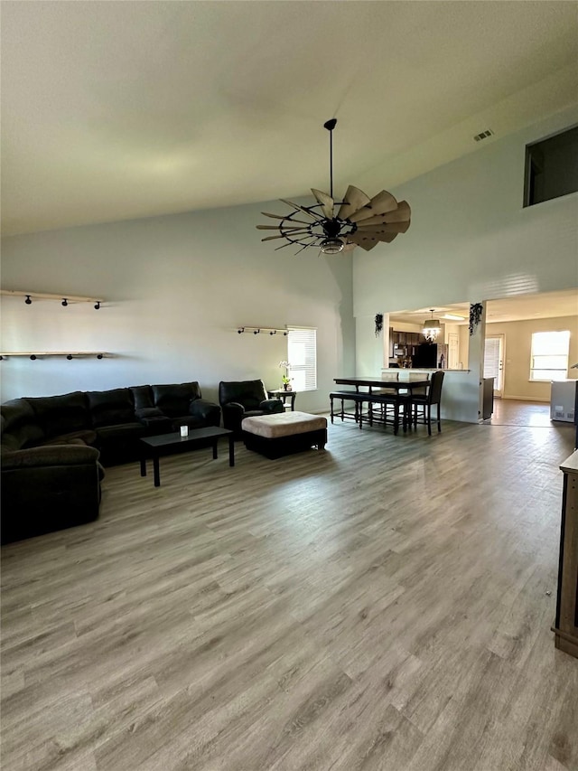 living room featuring hardwood / wood-style flooring, a wealth of natural light, high vaulted ceiling, and ceiling fan