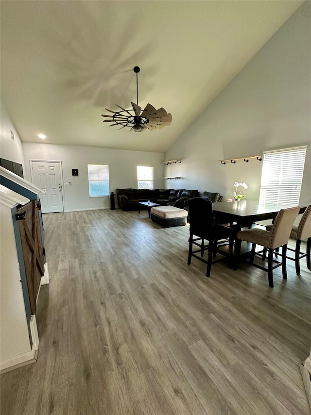 dining room featuring ceiling fan, high vaulted ceiling, and hardwood / wood-style floors