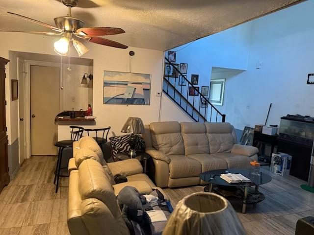 living room featuring a textured ceiling and ceiling fan