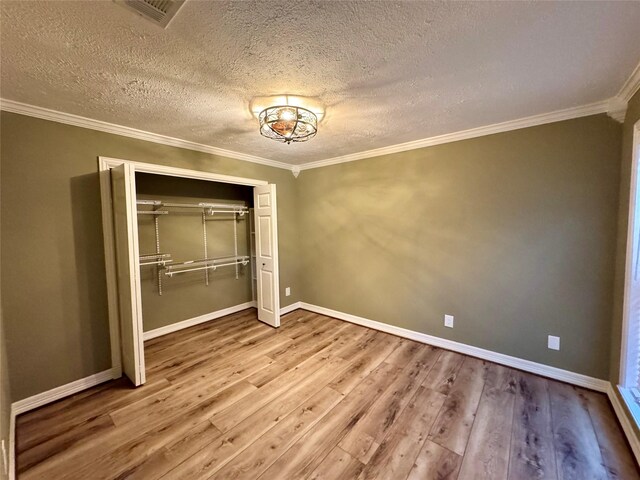 41 Driving Range Ln Unit 41, Trinity, TX 75862 - unfurnished bedroom with wood finished floors, a closet, a textured ceiling, ornamental molding, and baseboards