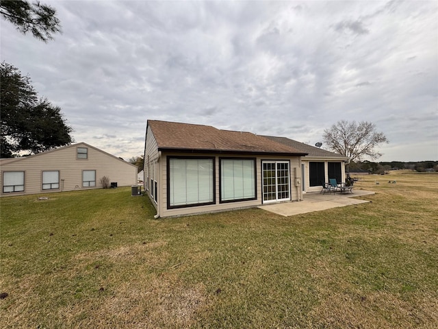 back of house with a patio area, a lawn, and central air condition unit