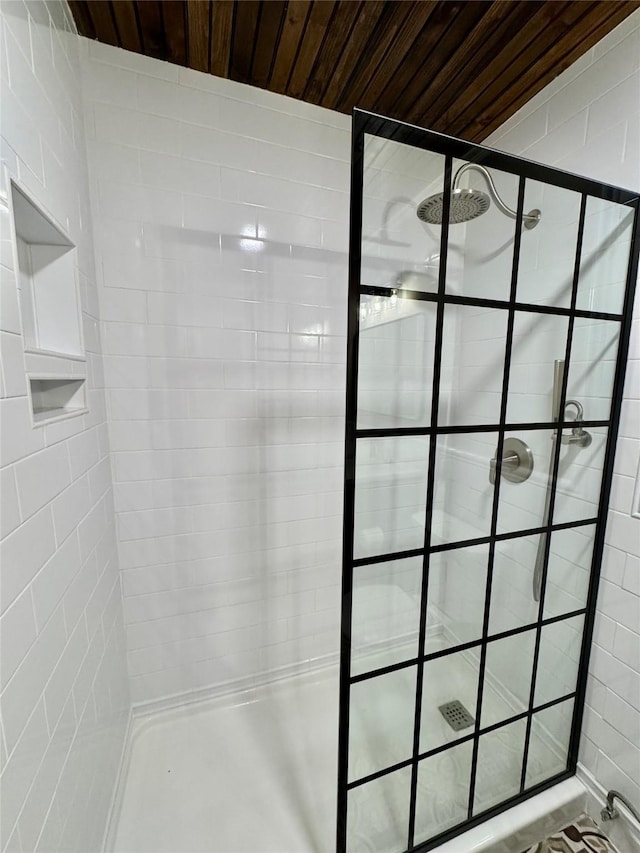 bathroom with tiled shower and wooden ceiling