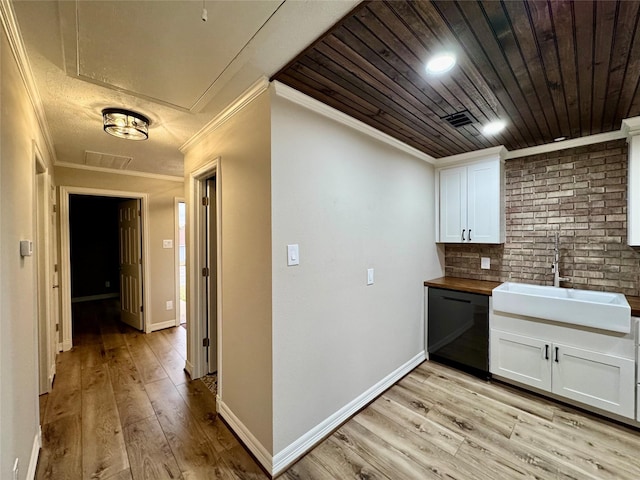 interior space with a sink, crown molding, wooden ceiling, and light wood-style floors