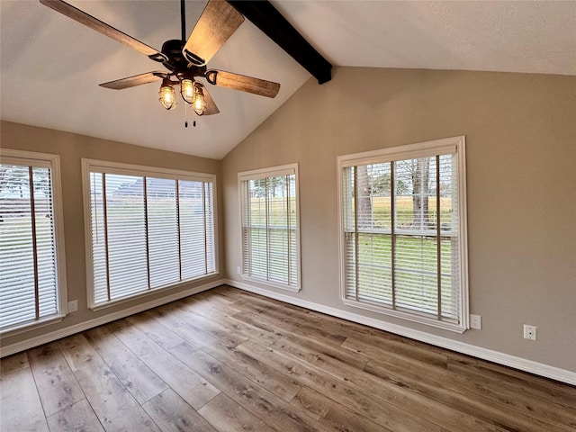 interior space featuring baseboards, vaulted ceiling with beams, ceiling fan, and wood finished floors