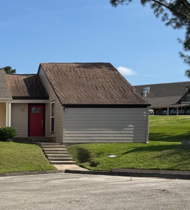 view of front of home with a front lawn and roof with shingles