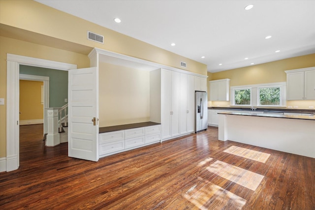 kitchen with stainless steel fridge with ice dispenser, white cabinets, and dark wood-type flooring