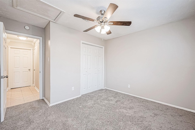 unfurnished bedroom with light colored carpet, a closet, and ceiling fan