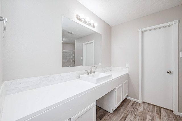 bathroom featuring vanity, hardwood / wood-style flooring, and a textured ceiling