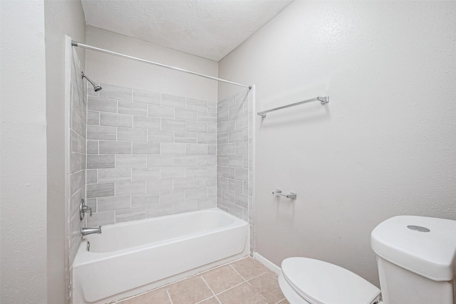 bathroom with a textured ceiling, toilet, tiled shower / bath combo, and tile patterned flooring