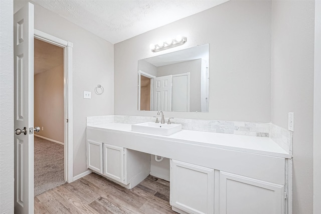 bathroom with wood-type flooring, a textured ceiling, and vanity