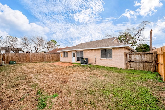 rear view of house featuring a patio, central AC unit, and a yard