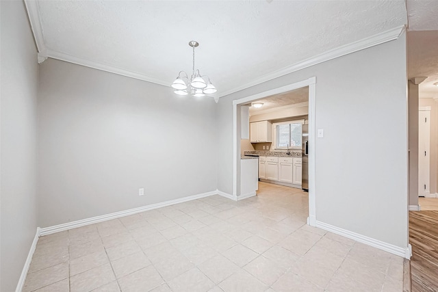 unfurnished room with sink, a notable chandelier, and ornamental molding