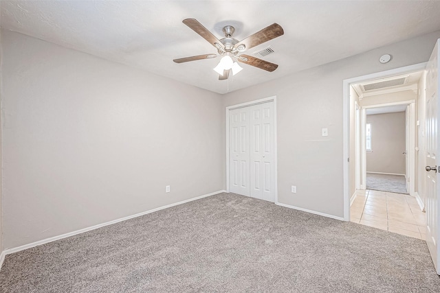 unfurnished bedroom featuring light carpet, a closet, and ceiling fan