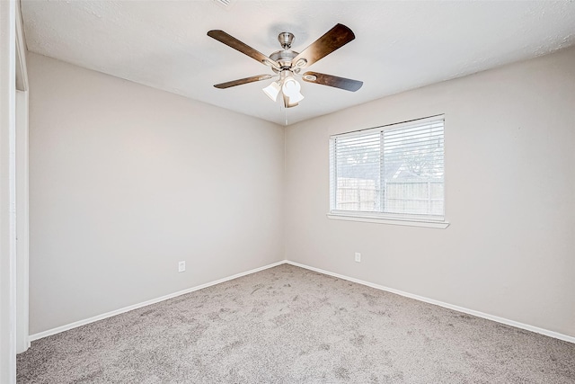 empty room featuring ceiling fan and carpet