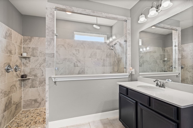 bathroom with tiled shower, vanity, and tile patterned floors