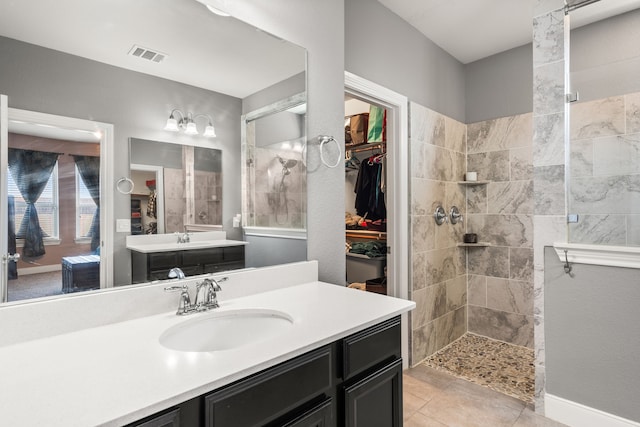 bathroom with vanity and a tile shower