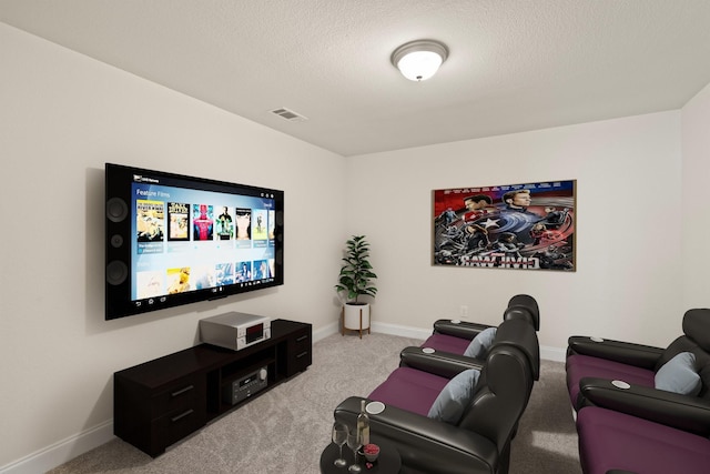 cinema room with light carpet and a textured ceiling