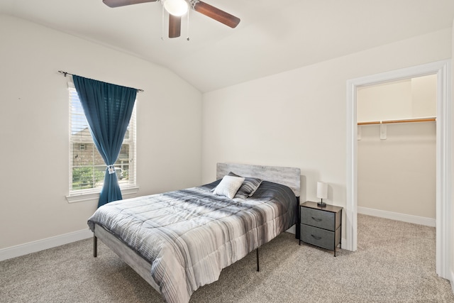 bedroom with ceiling fan, light colored carpet, a spacious closet, and vaulted ceiling