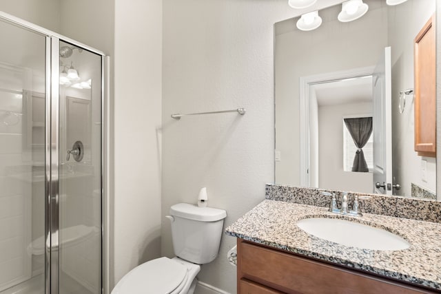 bathroom with vanity, toilet, and a shower with shower door