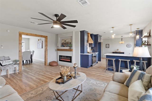 living room with light hardwood / wood-style floors and ceiling fan