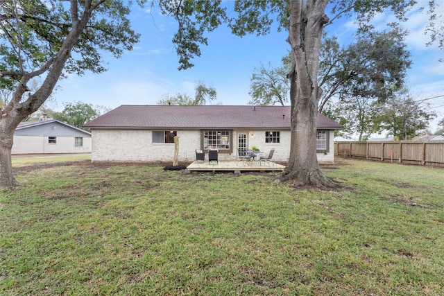 back of house with a lawn and a deck