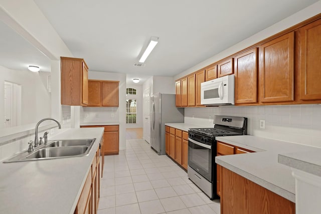 kitchen featuring sink, backsplash, stainless steel appliances, and light tile patterned flooring