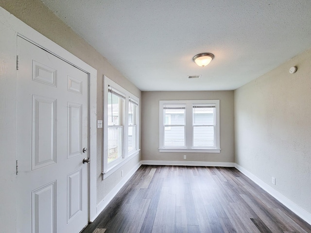 entryway with dark hardwood / wood-style flooring and a textured ceiling