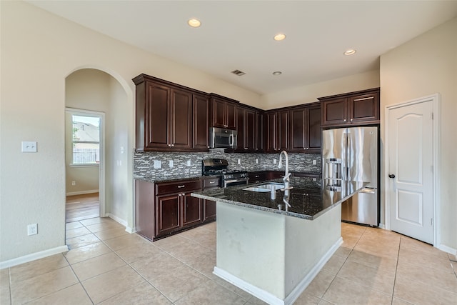 kitchen featuring sink, a center island with sink, appliances with stainless steel finishes, and light tile patterned flooring