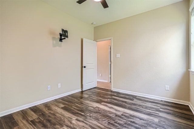 unfurnished room with ceiling fan and dark wood-type flooring