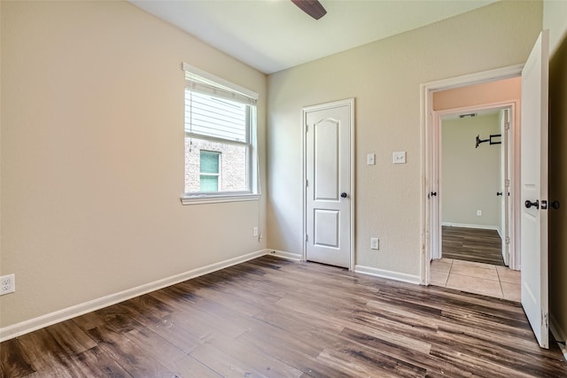 unfurnished bedroom with ceiling fan and light wood-type flooring