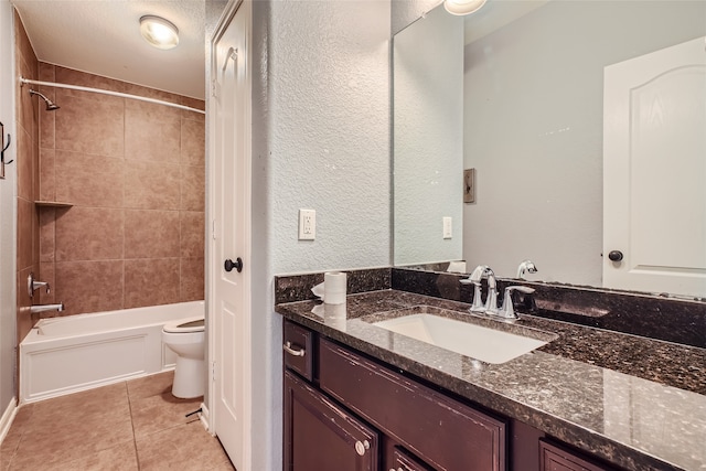 full bathroom with vanity, toilet, tiled shower / bath, and tile patterned flooring