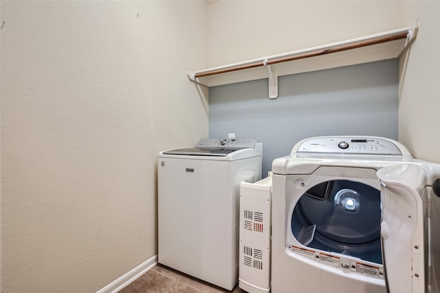 clothes washing area with light tile patterned floors and independent washer and dryer