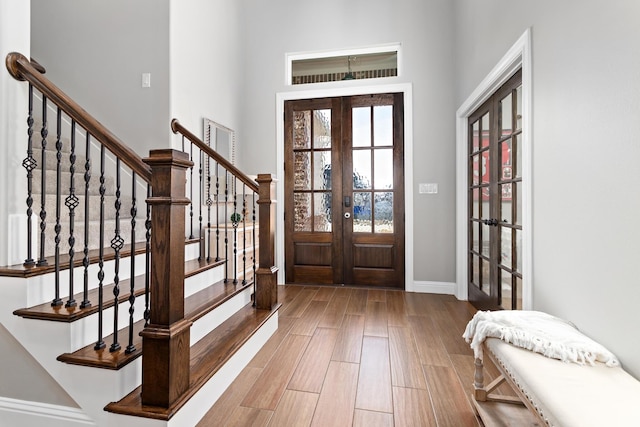 foyer with french doors and light hardwood / wood-style floors