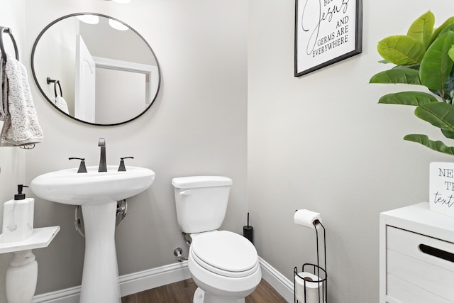 bathroom featuring wood-type flooring and toilet