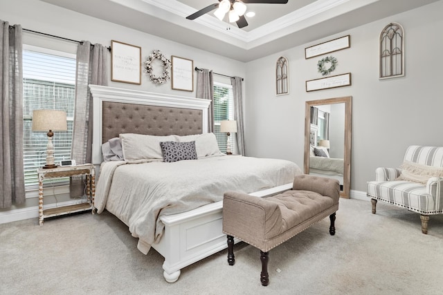 carpeted bedroom featuring crown molding, a tray ceiling, and ceiling fan