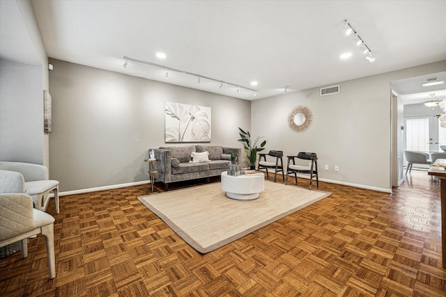 living room featuring track lighting, visible vents, and baseboards